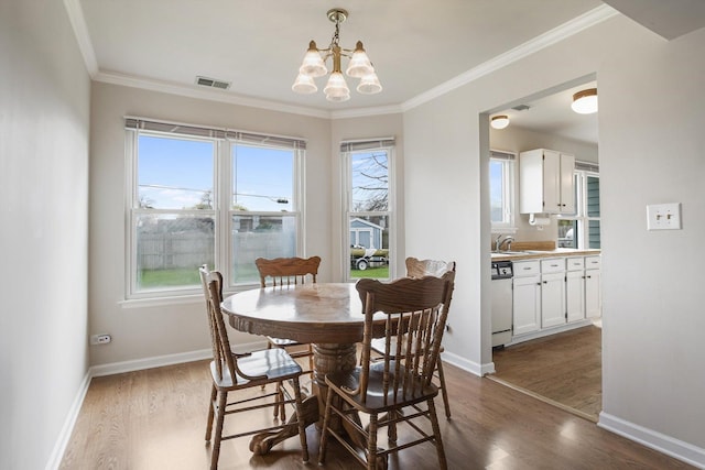 1005 Thomas Blvd, Mundelein, IL 60060 - dining area featuring visible vents, crown molding, wood finished floors, baseboards, and a notable chandelier