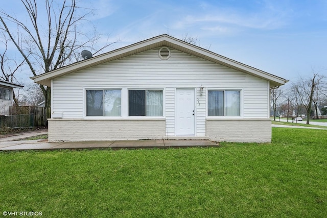 view of front of house featuring a front yard, fence, and brick siding