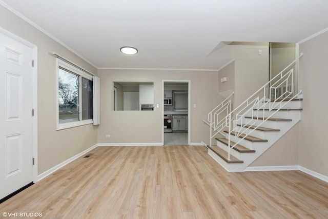 foyer entrance with baseboards, wood finished floors, stairs, and ornamental molding