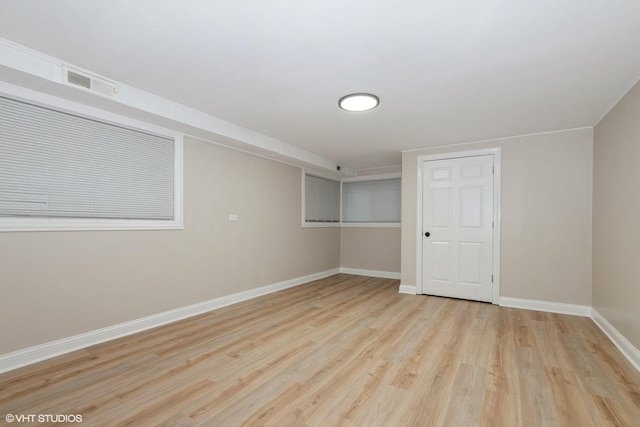 unfurnished room with visible vents, wood finished floors, and baseboards