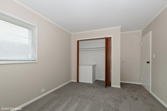 unfurnished bedroom with crown molding, a closet, carpet floors, and baseboards