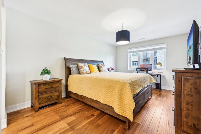 bedroom with baseboards and light wood finished floors