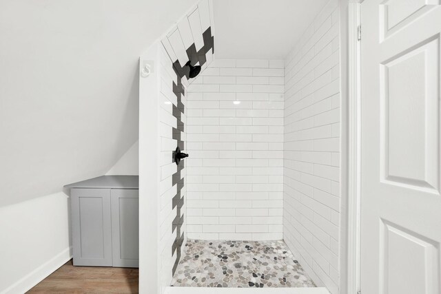 bathroom with wood finished floors and a stall shower