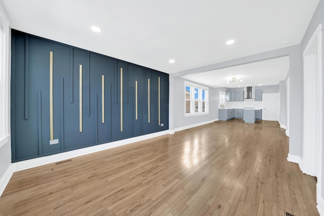 unfurnished living room featuring visible vents, light wood-type flooring, recessed lighting, and baseboards