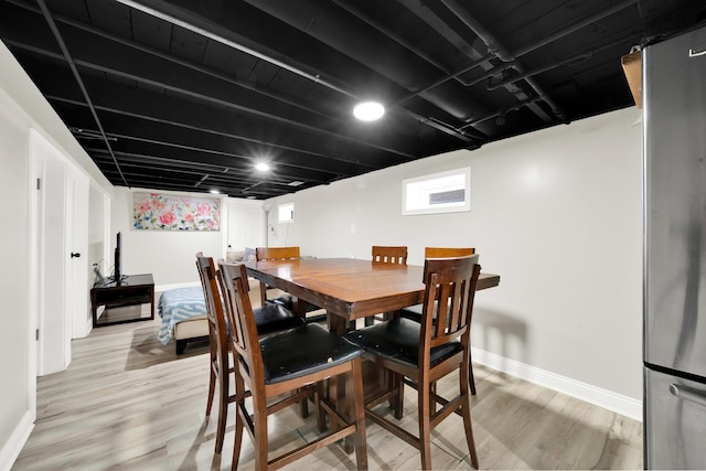 dining space featuring baseboards and light wood-style floors