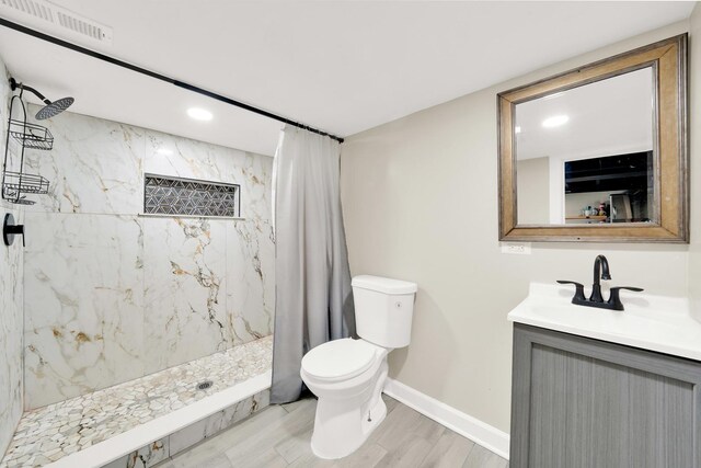 bathroom featuring a shower stall, vanity, toilet, visible vents, and baseboards