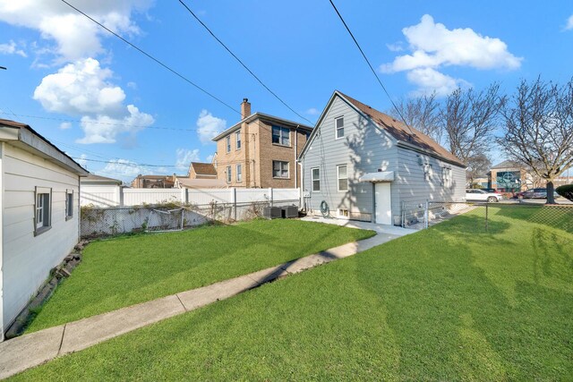 rear view of property with a yard and fence