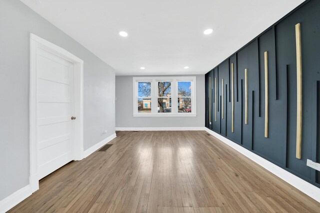 unfurnished room featuring wood finished floors, recessed lighting, visible vents, and baseboards