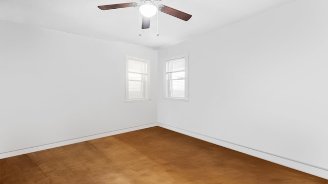 empty room with a ceiling fan and baseboards