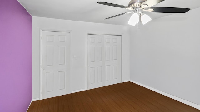 unfurnished bedroom featuring a closet, ceiling fan, wood finished floors, and baseboards