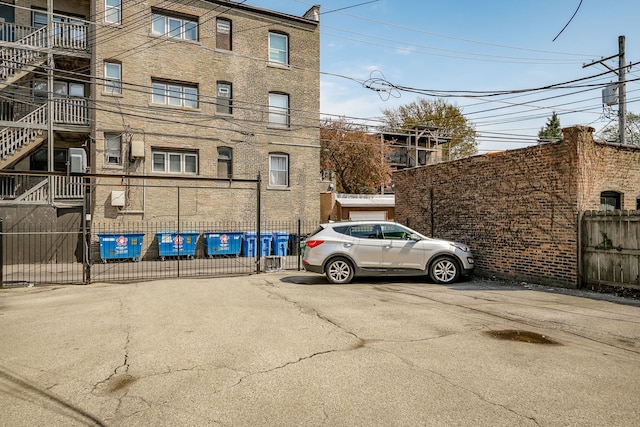 view of property with fence and uncovered parking
