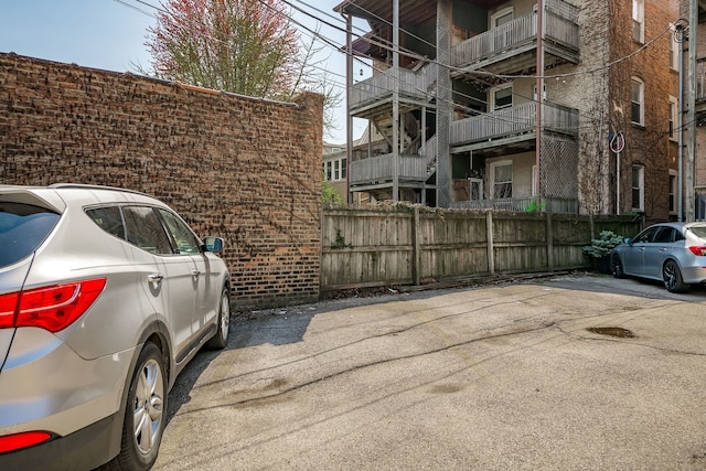 view of vehicle parking featuring fence