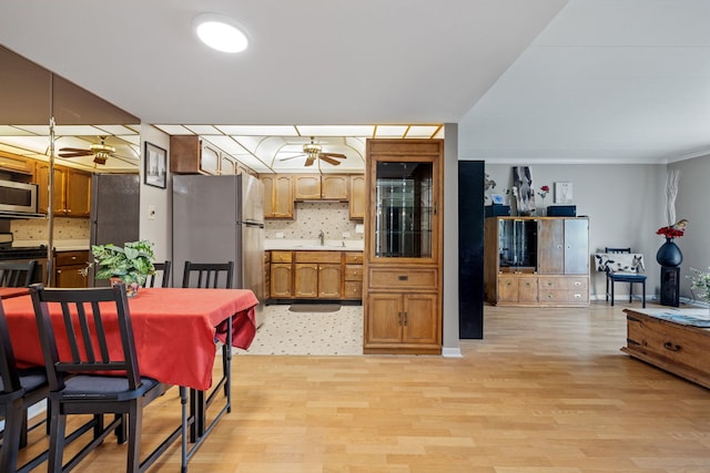 5540 Walnut Ave Unit 22C, Downers Grove, IL 60515 - kitchen with a ceiling fan, appliances with stainless steel finishes, a sink, and light wood-type flooring