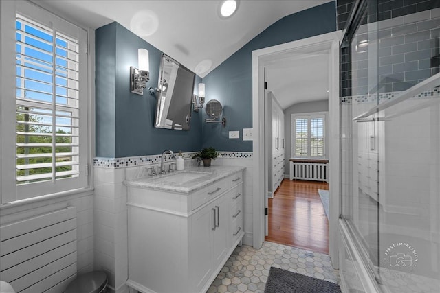 6N225 Circle Ave, Medinah, IL 60157 - bathroom with radiator heating unit, lofted ceiling, vanity, tile walls, and shower / bath combination with glass door