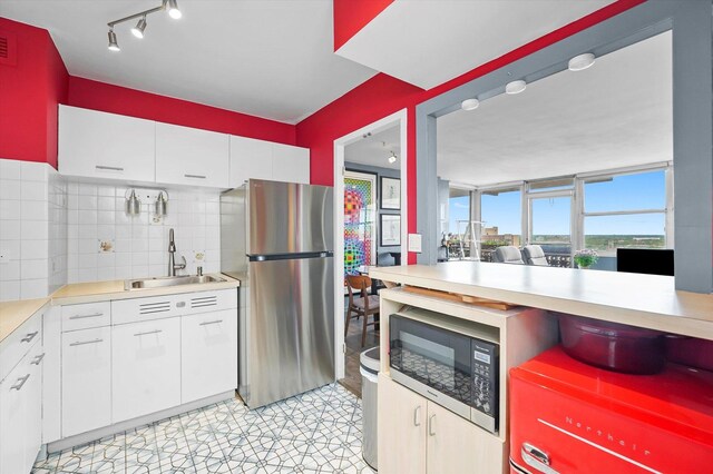 6301 N Sheridan Rd Unit 20J, Chicago, IL 60660 - kitchen featuring freestanding refrigerator, a sink, built in microwave, light countertops, and decorative backsplash