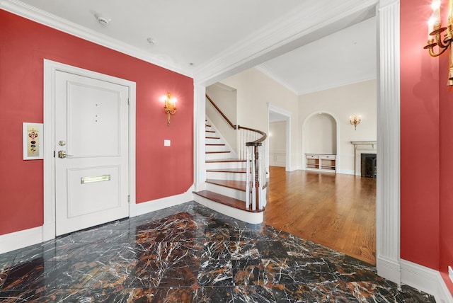 entryway featuring crown molding, stairway, baseboards, a fireplace, and marble finish floor