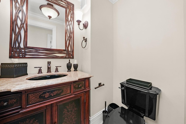 bathroom featuring visible vents, vanity, ornamental molding, and baseboards