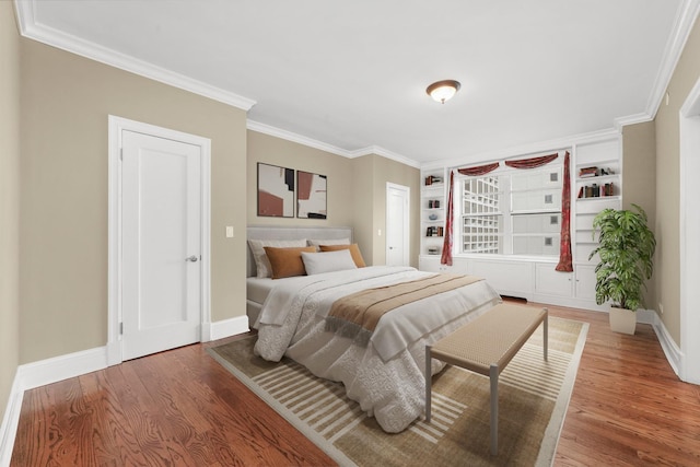 bedroom featuring ornamental molding, wood finished floors, and baseboards