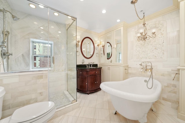 full bathroom featuring a stall shower, tile walls, a freestanding bath, and vanity