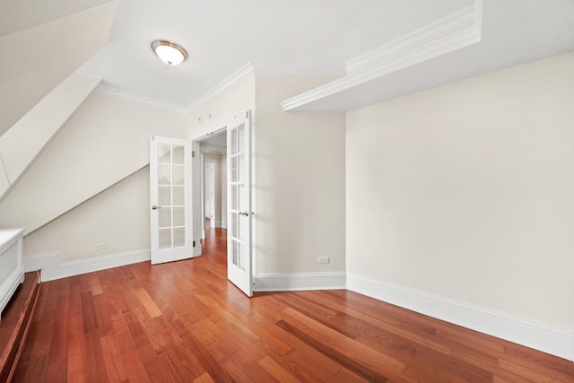 bonus room featuring baseboards, wood finished floors, and french doors