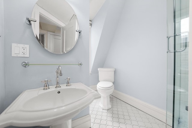 bathroom featuring baseboards, tile patterned floors, toilet, and a sink