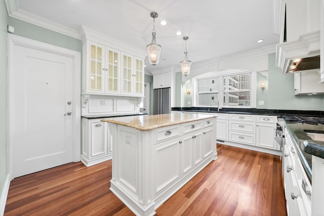 kitchen featuring wood finished floors, ornamental molding, and white cabinetry