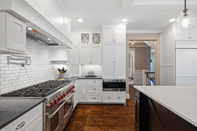 kitchen featuring high end appliances, crown molding, white cabinets, dark wood-type flooring, and recessed lighting