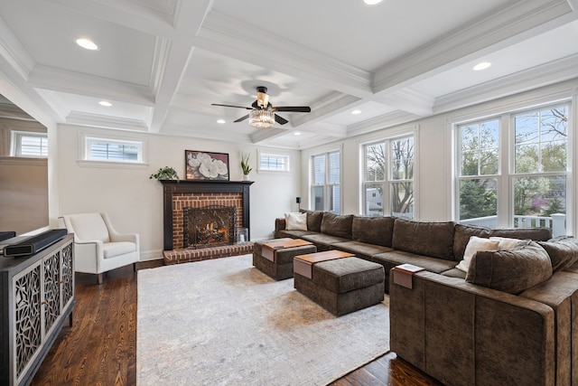 living room featuring dark wood-style floors, a ceiling fan, beamed ceiling, a brick fireplace, and coffered ceiling
