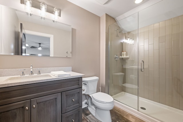 full bath featuring a stall shower, a ceiling fan, toilet, and vanity