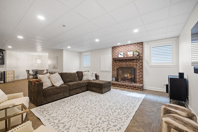 living room featuring a brick fireplace, baseboards, recessed lighting, and beverage cooler
