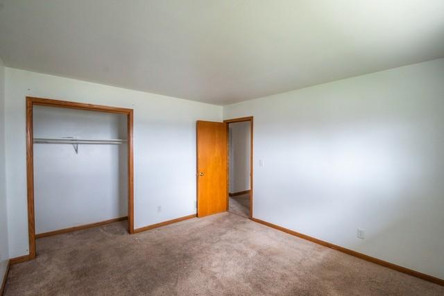 34830 47th St, Burlington, WI 53105 - unfurnished bedroom with baseboards, carpet floors, and a closet