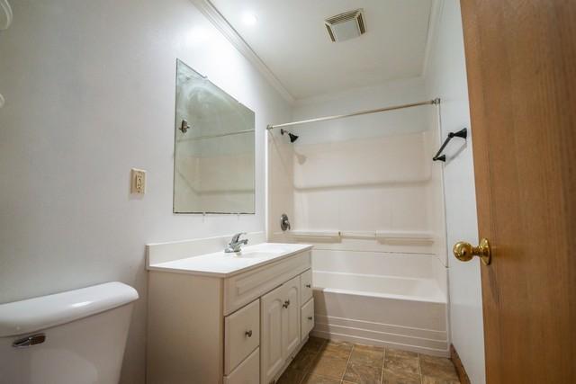 34830 47th St, Burlington, WI 53105 - full bath with washtub / shower combination, visible vents, toilet, and vanity