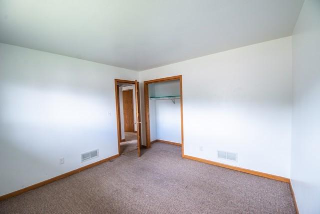 34830 47th St, Burlington, WI 53105 - unfurnished bedroom with baseboards, visible vents, a closet, and carpet flooring