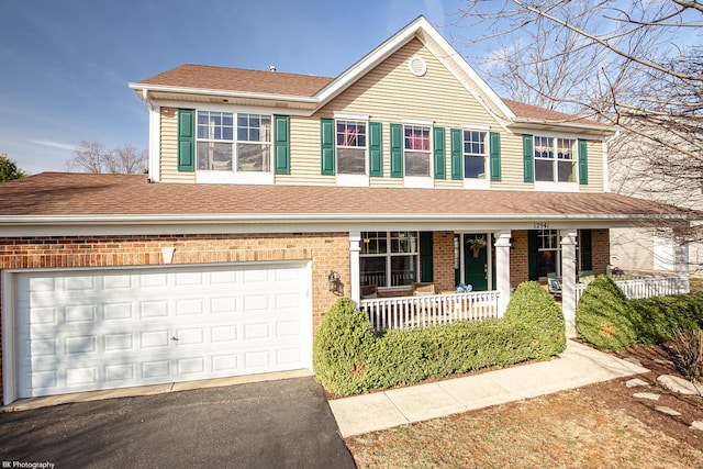 12941 Grande Poplar Cir, Plainfield, IL 60585 - traditional home featuring a porch, a shingled roof, aphalt driveway, brick siding, and an attached garage