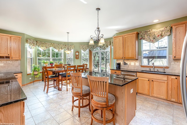 12941 Grande Poplar Cir, Plainfield, IL 60585 - kitchen with stainless steel dishwasher, a sink, a wealth of natural light, and a kitchen island
