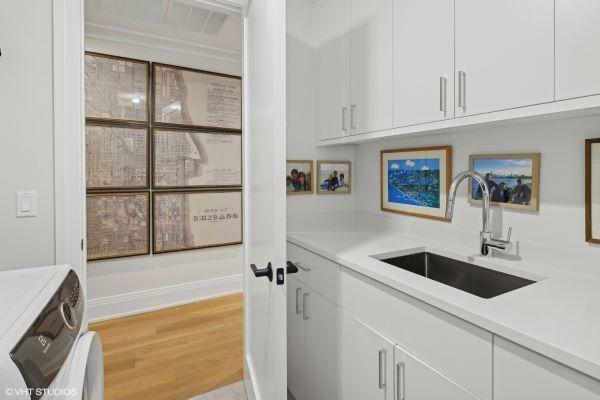 laundry room with washer and dryer, a sink, cabinet space, and light wood-type flooring