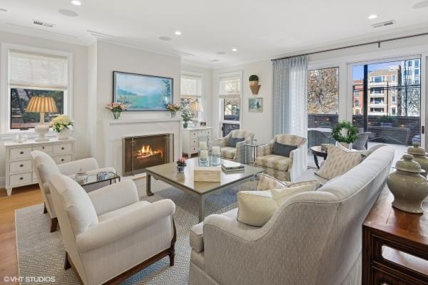 living area featuring recessed lighting, ornamental molding, a healthy amount of sunlight, and a warm lit fireplace