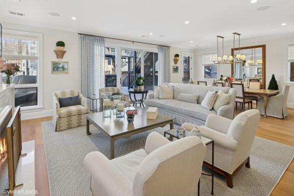 living area with wood finished floors, plenty of natural light, and crown molding