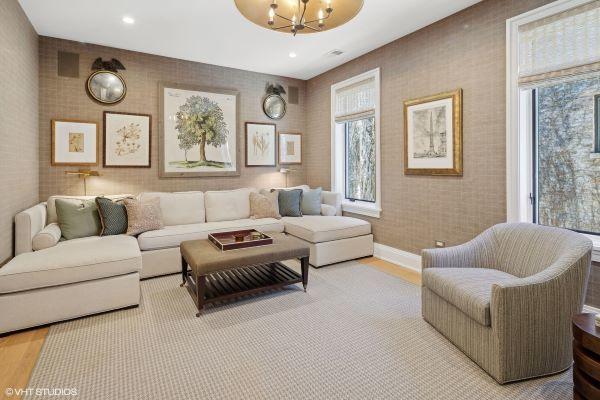 living area featuring baseboards, recessed lighting, wood finished floors, and an inviting chandelier