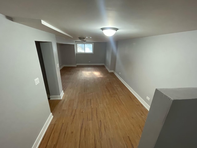 hall featuring baseboards and wood finished floors