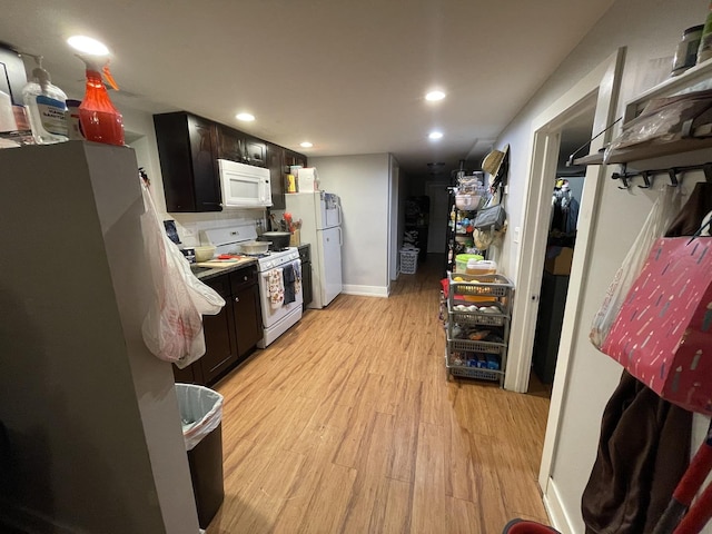 kitchen with recessed lighting, baseboards, dark brown cabinets, white appliances, and light wood-style floors