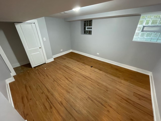 below grade area with baseboards and wood finished floors