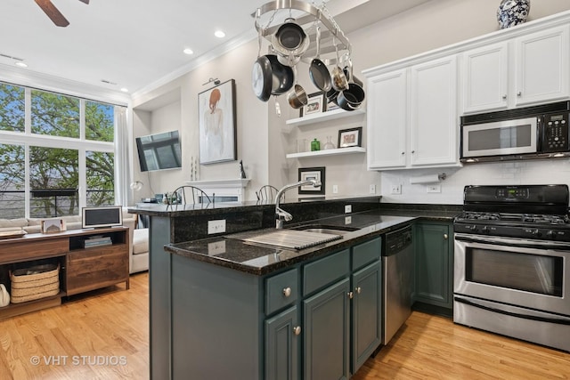 2512 W Thomas St Unit 3, Chicago, IL 60622 - kitchen featuring crown molding, appliances with stainless steel finishes, open shelves, a peninsula, and white cabinetry