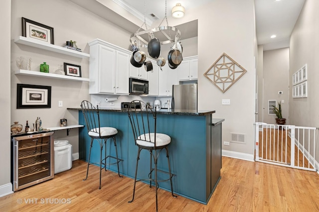 2512 W Thomas St Unit 3, Chicago, IL 60622 - kitchen featuring visible vents, light wood-type flooring, white cabinets, freestanding refrigerator, and wine cooler