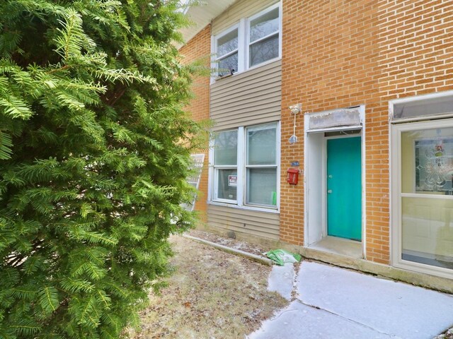 doorway to property with brick siding