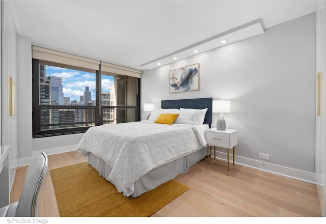 1030 N State St Unit 21K, Chicago, IL 60610 - bedroom with recessed lighting, baseboards, a city view, and light wood-style floors