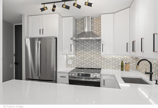 1030 N State St Unit 21K, Chicago, IL 60610 - kitchen featuring wall chimney range hood, decorative backsplash, a sink, appliances with stainless steel finishes, and light countertops