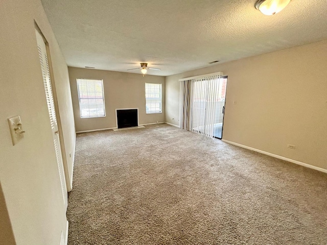 1915 N Hicks Rd Unit 105, Palatine, IL 60074 - unfurnished living room with a fireplace, a ceiling fan, baseboards, a textured ceiling, and carpet floors
