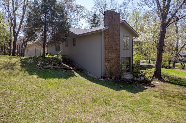 view of property exterior featuring a lawn and a chimney