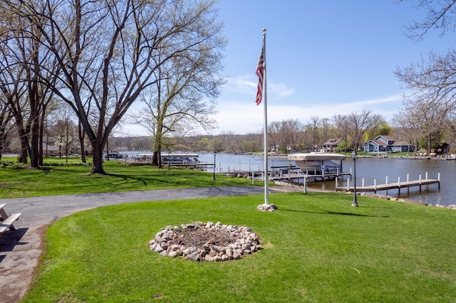 view of dock with a lawn, a water view, and boat lift